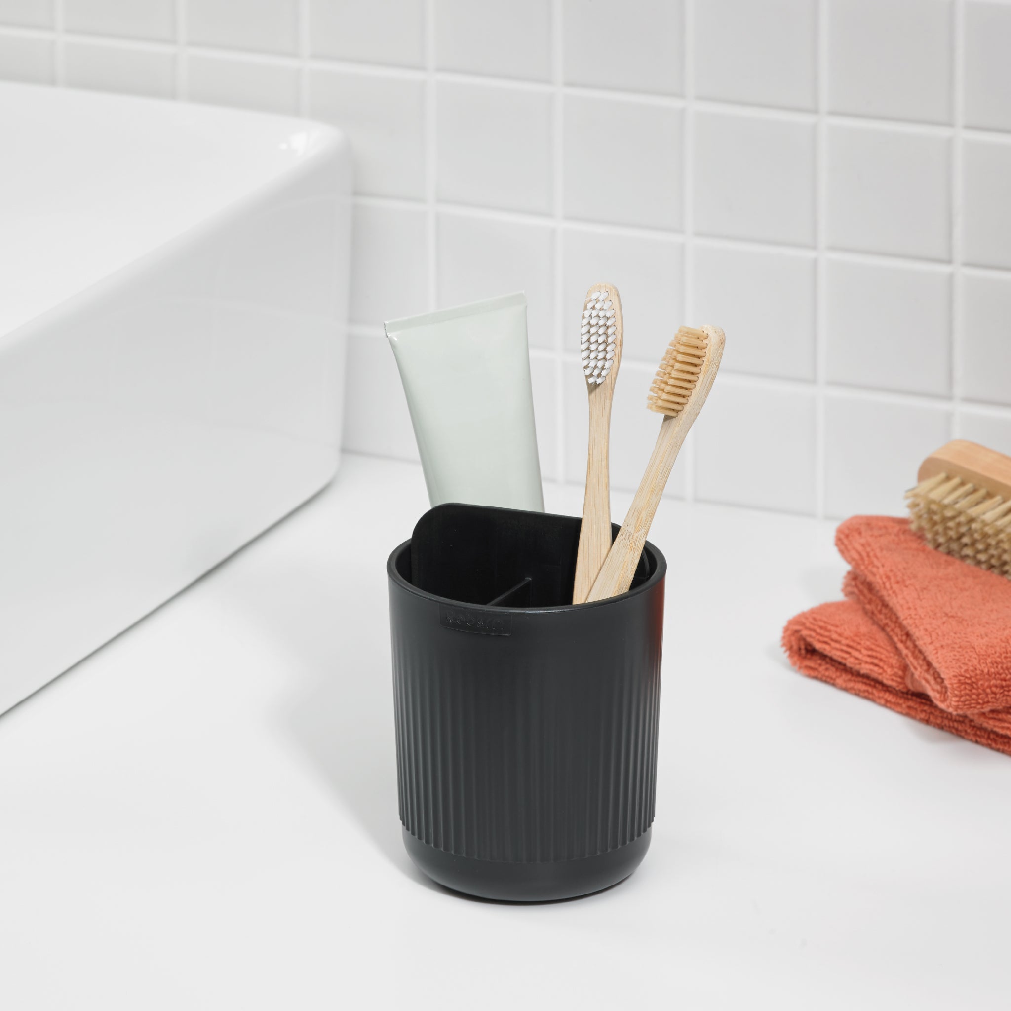 Black ReBorn toothbrush holder with ridged design, keeps brushes organized and countertops tidy.
