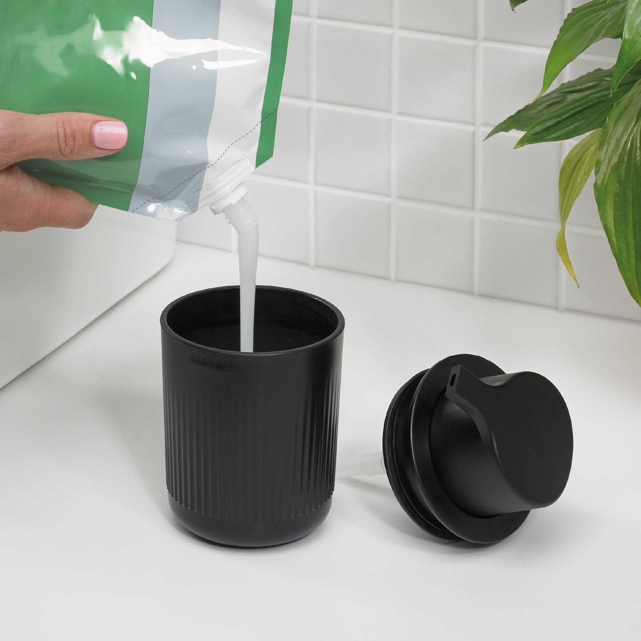 Refillable black soap dispenser with stylish ridged design—reduces plastic waste and elevates decor.