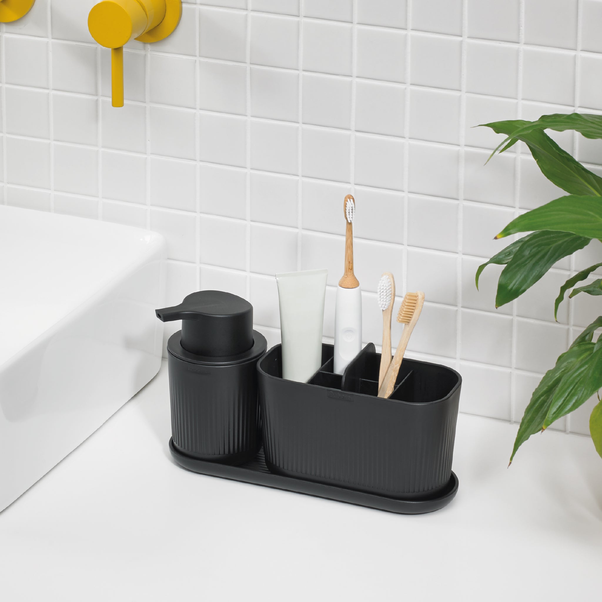 Modern black bathroom organizer tray with compartments, includes matching soap dispenser for clutter-free countertops.