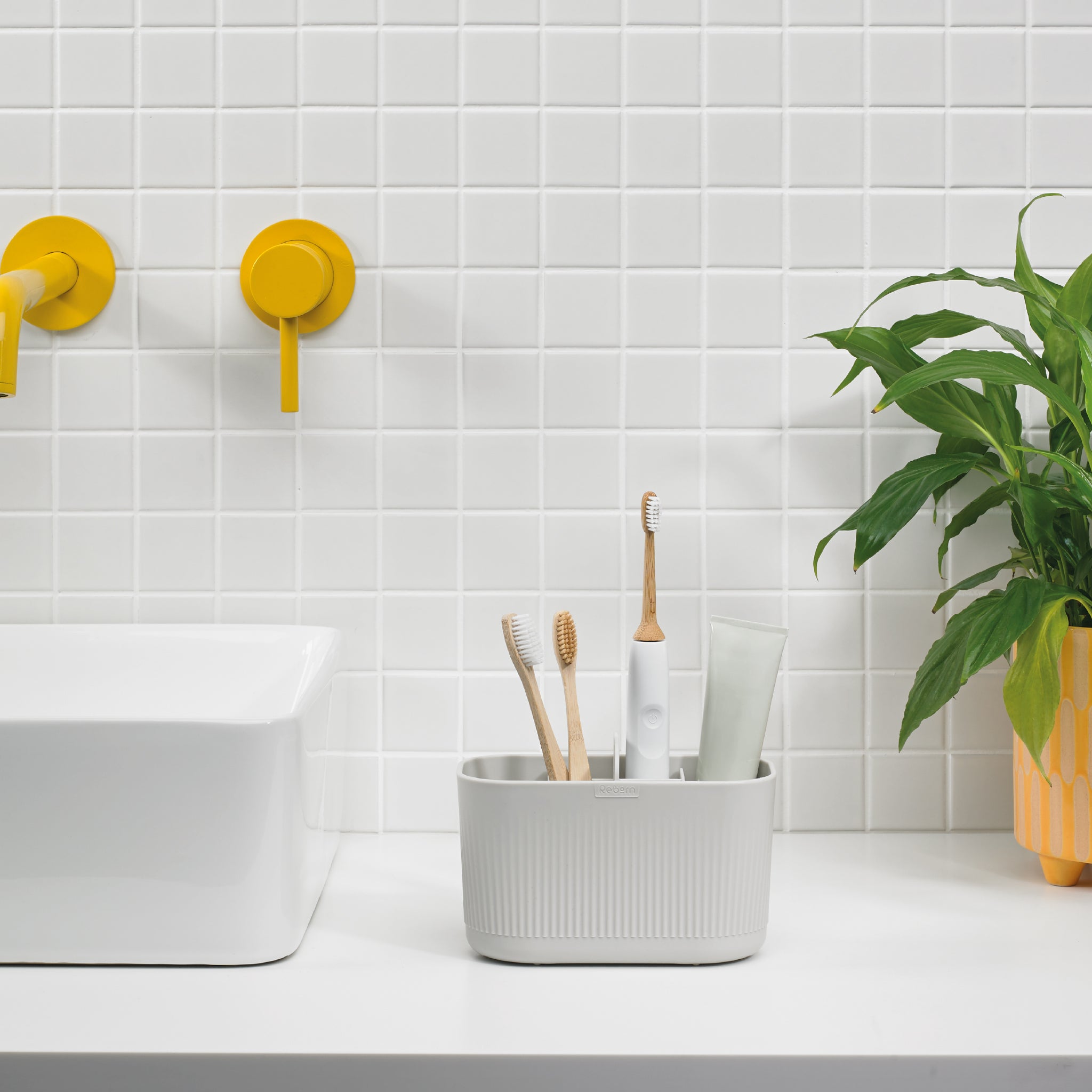 White ribbed bathroom caddy keeps toothbrushes and toiletries organized, stylish, and easily accessible.