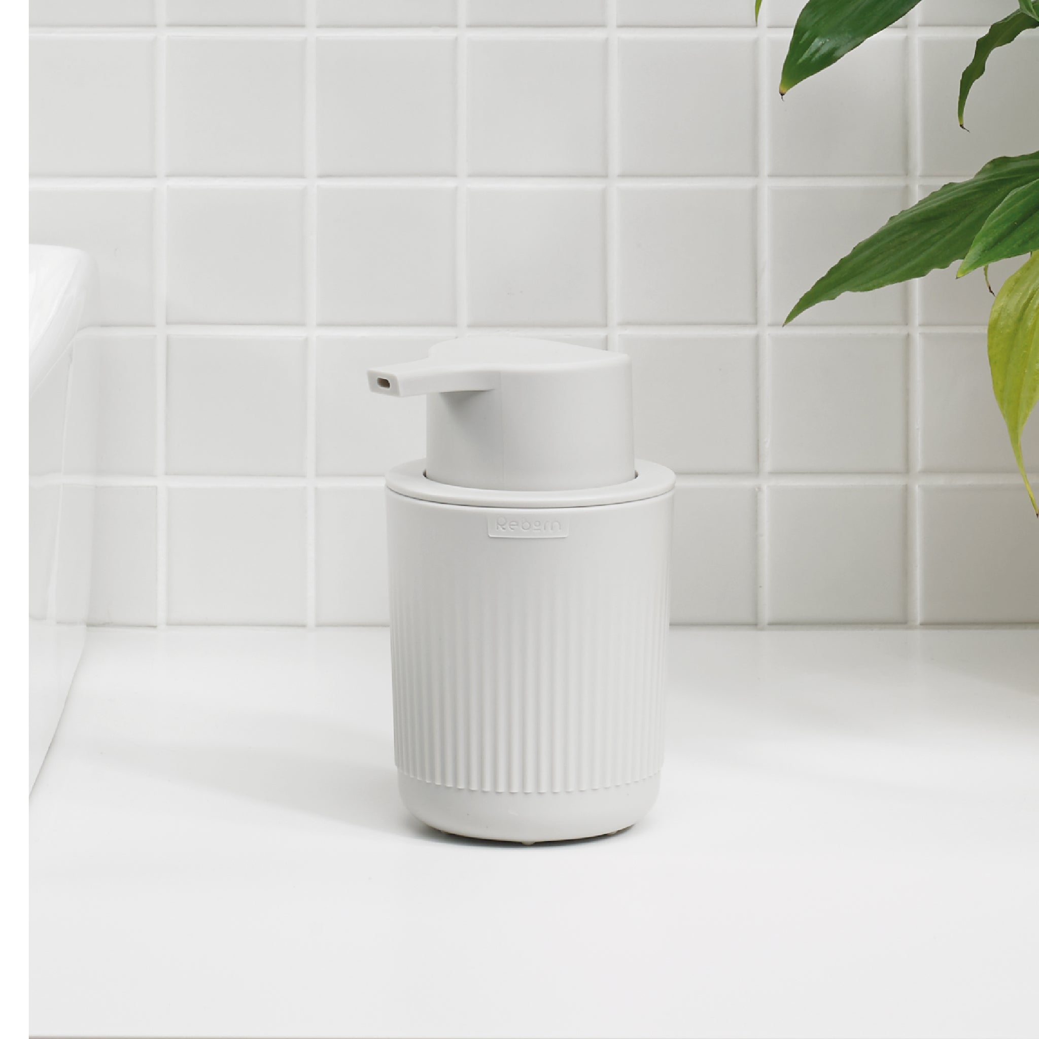 White ribbed soap dispenser with pump, modern design for stylish, clutter-free countertops.