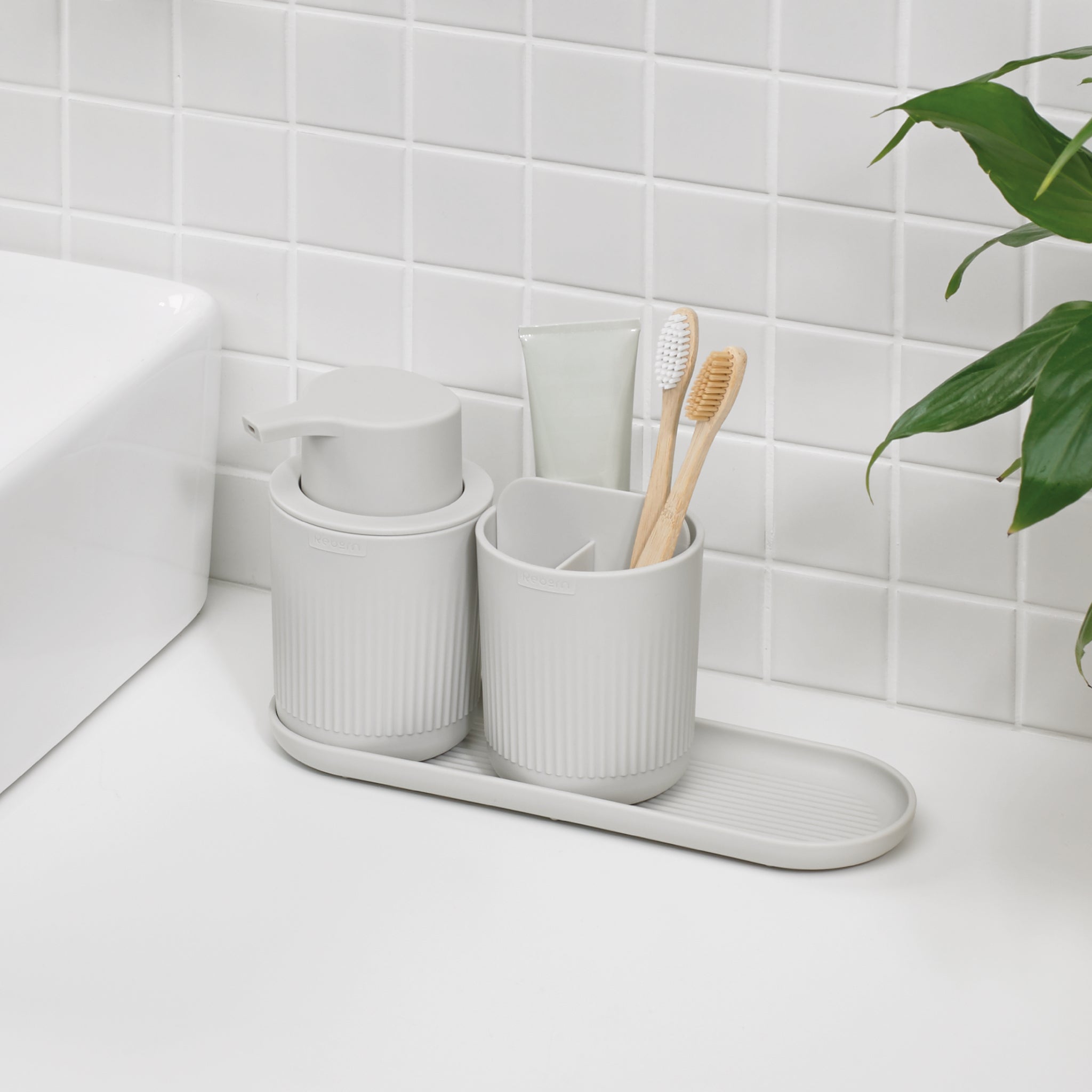 Modern graphite black bathroom set with ribbed texture, includes soap dispenser, toothbrush holder, and tray for organized countertops.