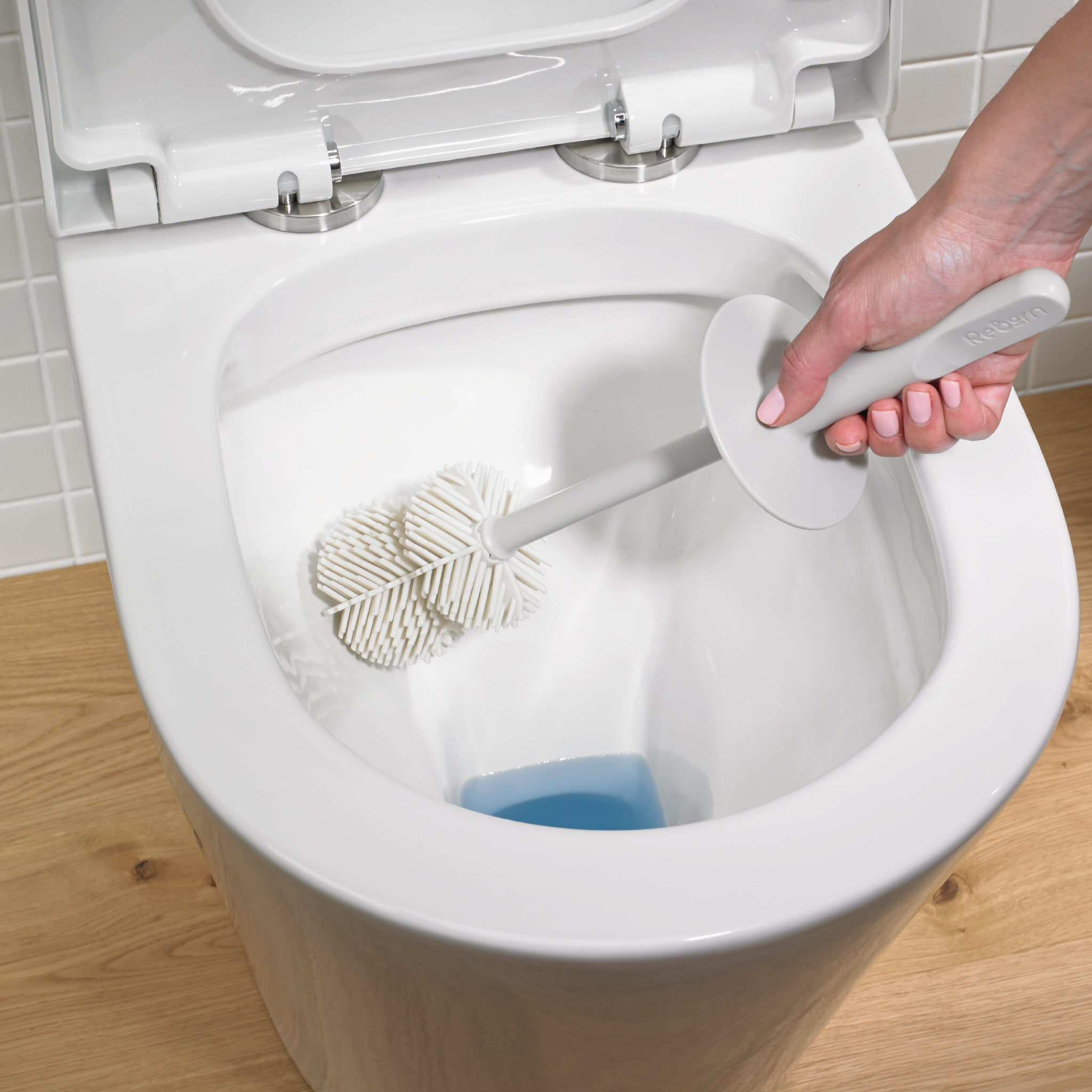 ReBorn toilet brush with flexible, ribbed head for thorough, scratch-free cleaning in any bowl.