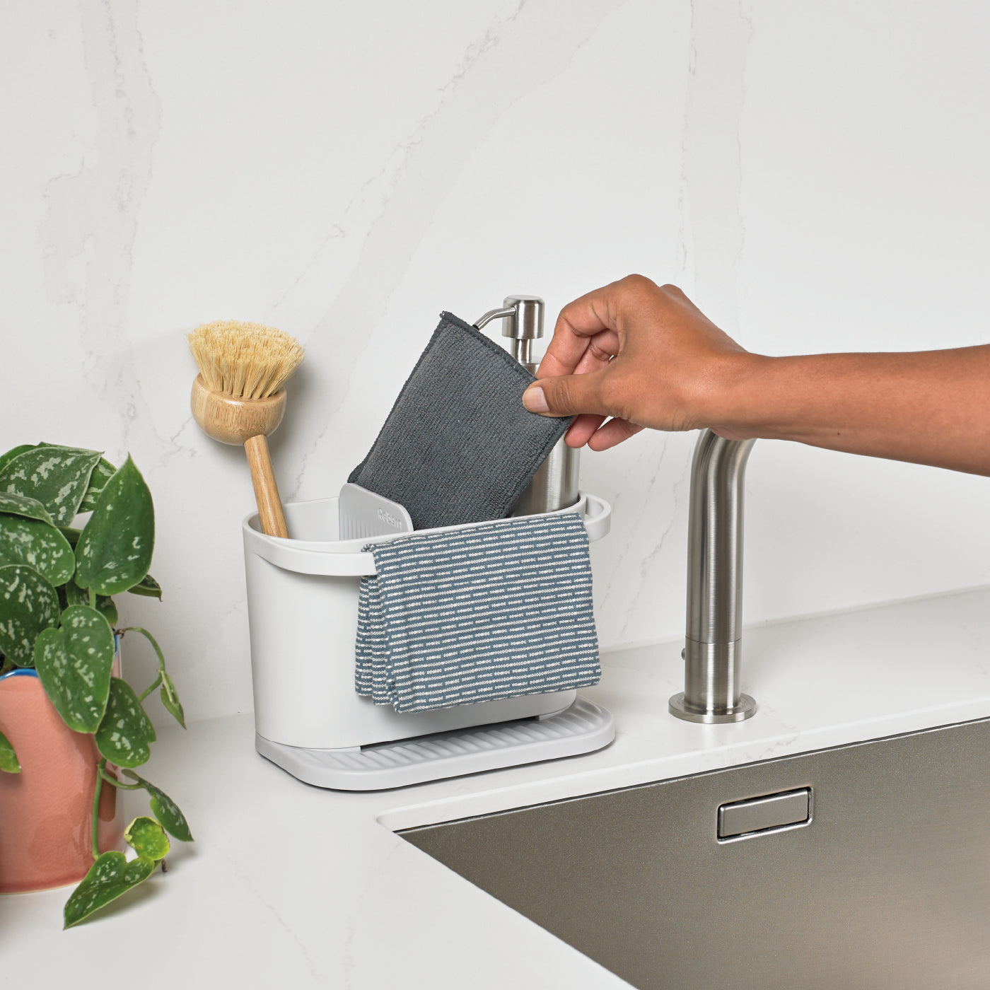 Recycled kitchen sink tidy with handle, keeps sponges, brushes, and soap organized neatly.