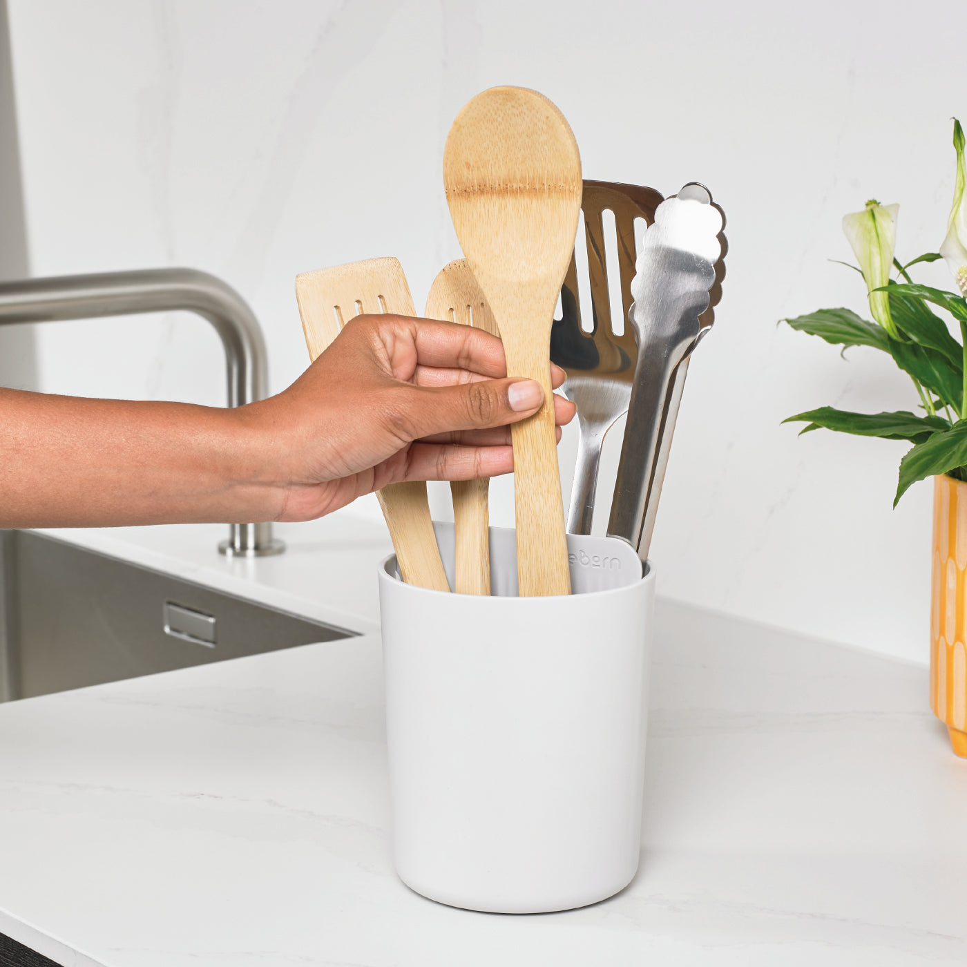 Eco-friendly recycled utensil holder keeps kitchen tools organized and within easy reach.