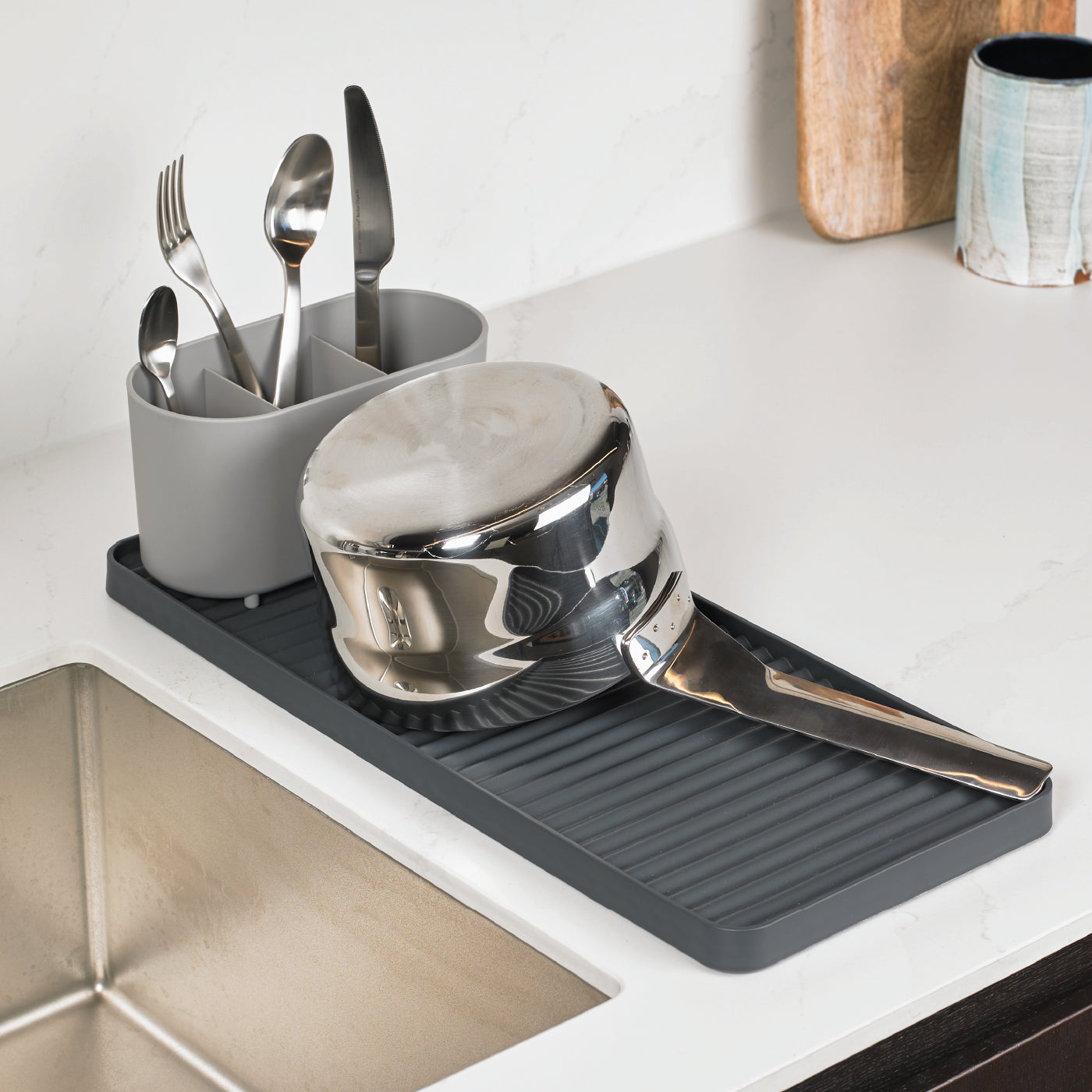Compact gray draining rack with ribbed surface for efficient drying, includes utensil holder.