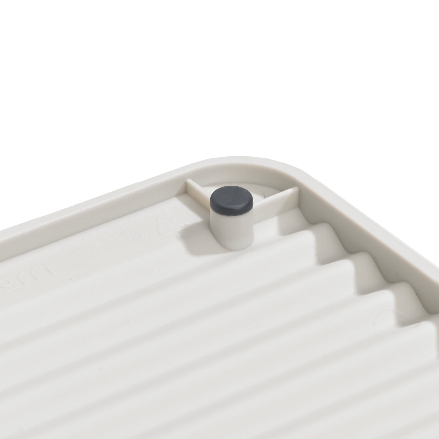 Compact recycled draining rack with a ridged surface for efficient drying and eco-friendly design.