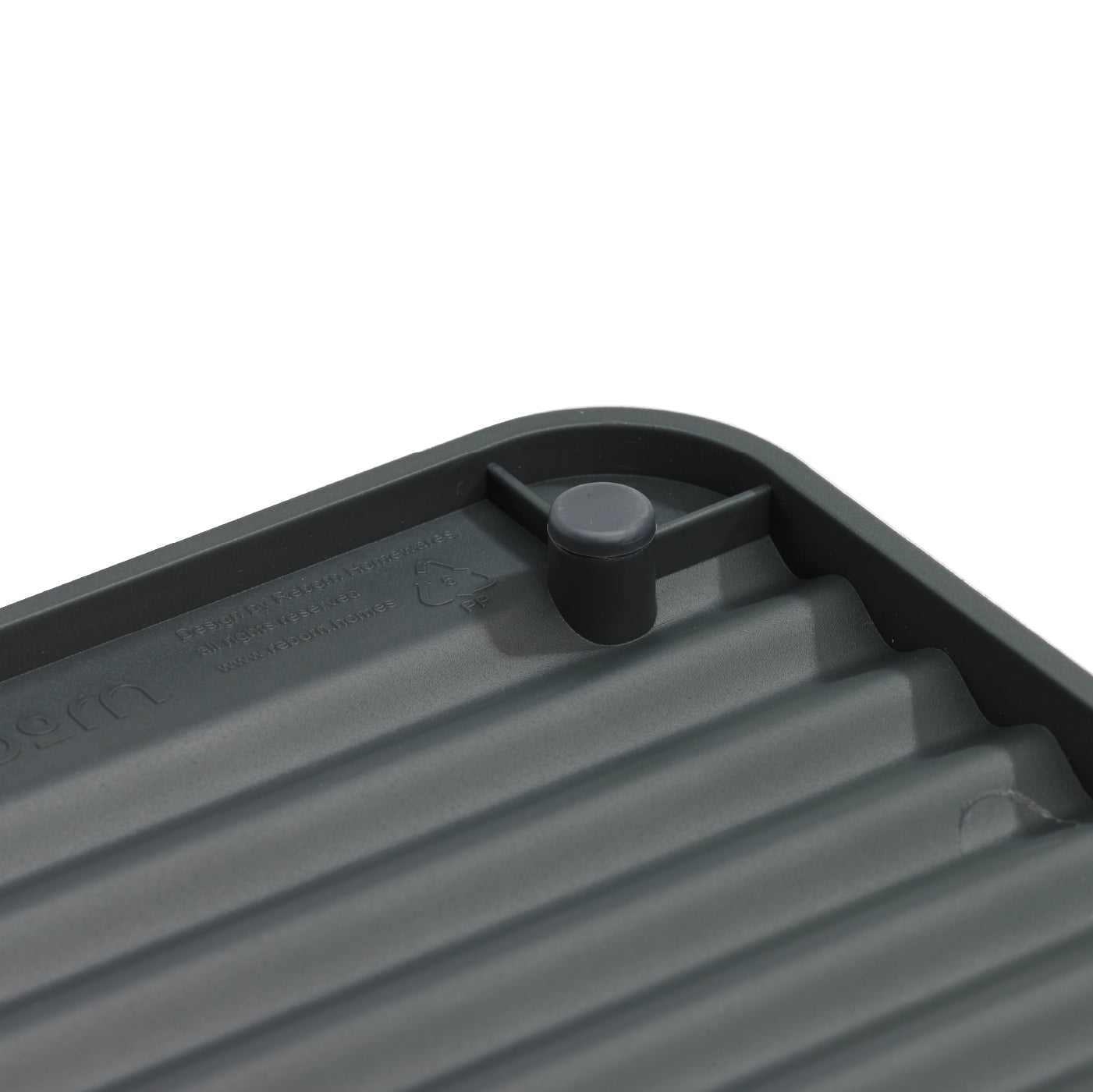 Compact recycled draining rack with ribbed texture for stability and efficient water drainage.