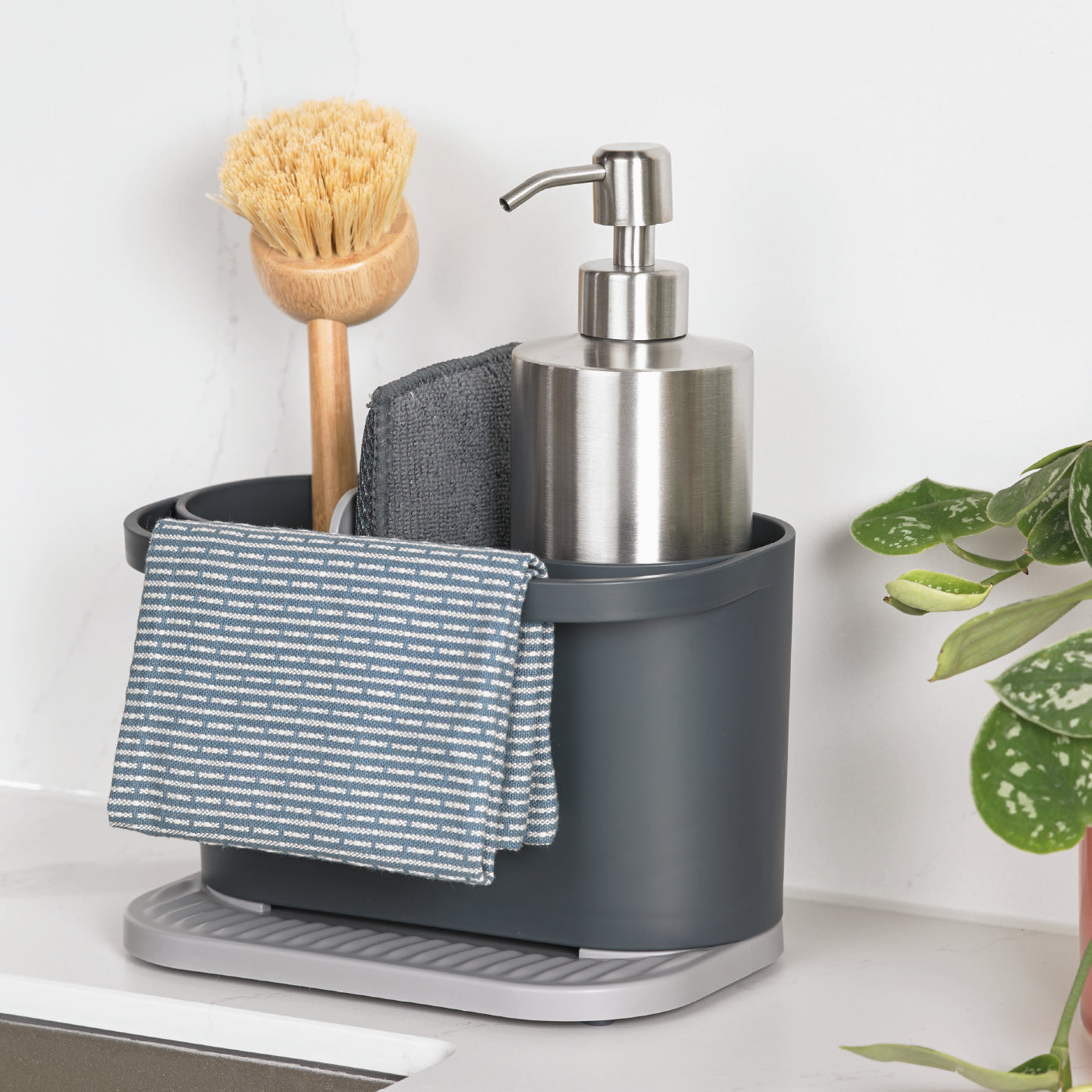Recycled kitchen sink tidy with compartments, includes brush, soap dispenser, and cloth for organized, eco-friendly cleaning.