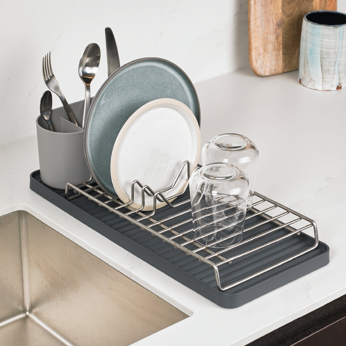 Compact recycled dish drying rack with organized sections for plates, glasses, and utensils.