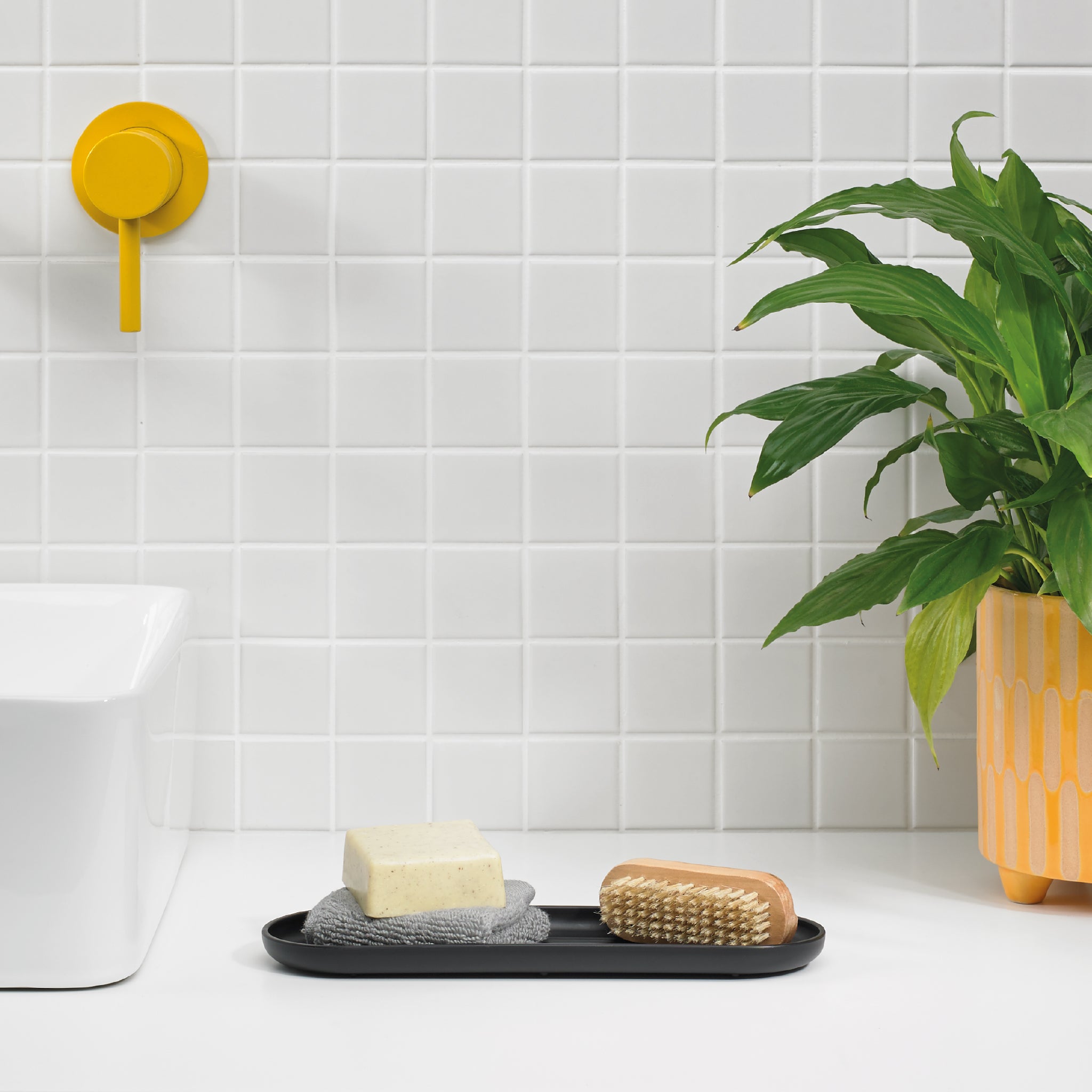 Sleek black bathroom tray keeps soaps and essentials organized, adding a modern touch.
