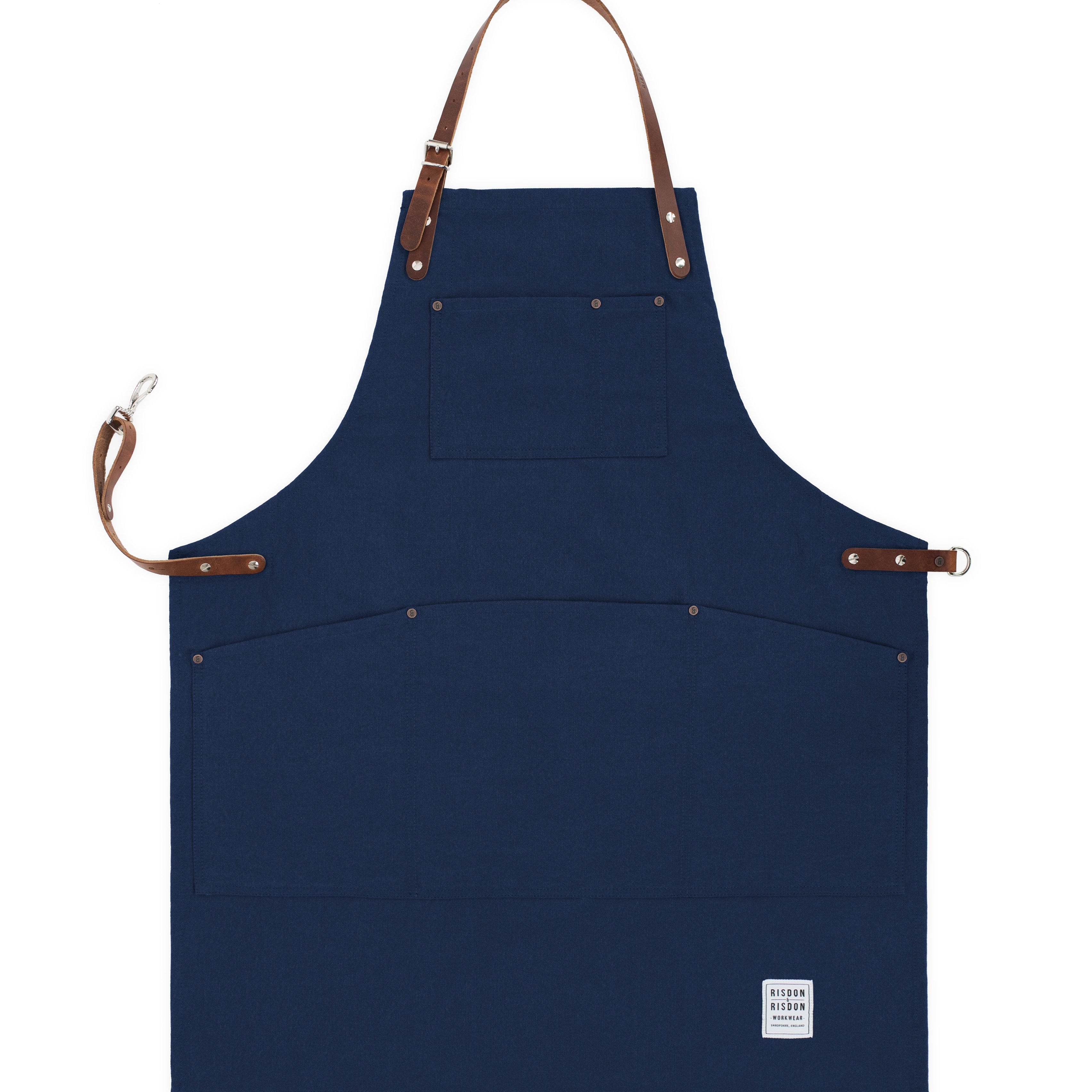Handcrafted, navy blue canvas apron; made in Britain with pockets and removable leather straps.