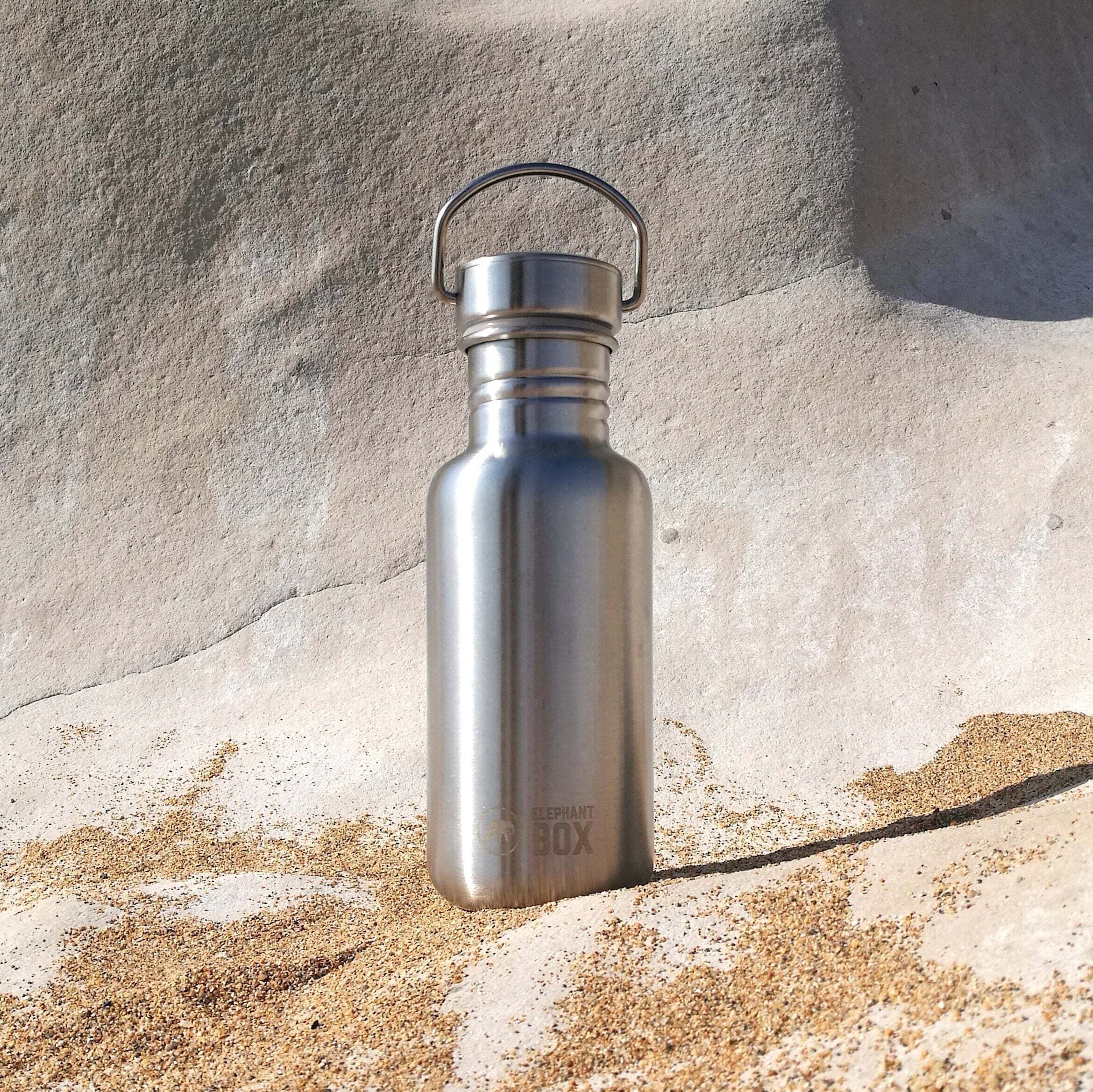 elephant box single wall 5000ml water bottle perched on rock on a beach.